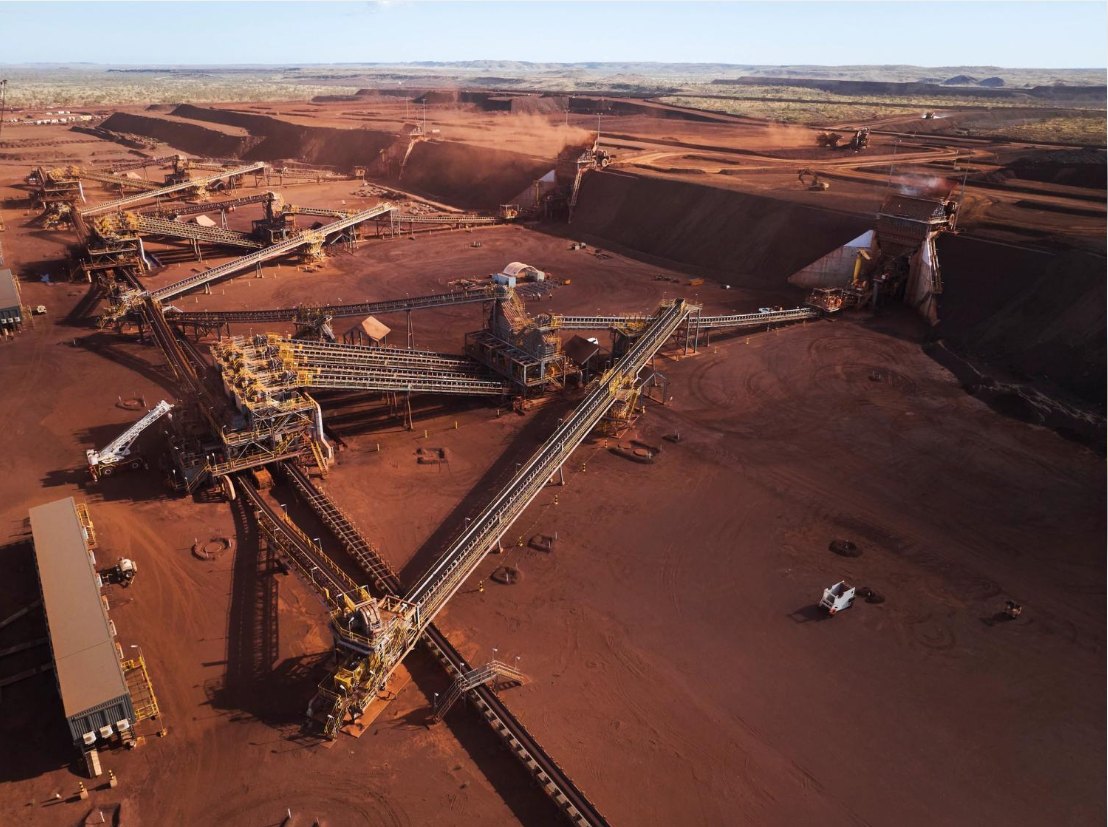 Aerial view of conveyors and stockpile infrastructure at a Pilbara iron ore processing operation
